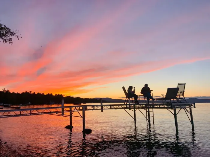 Framed Print : Mother and daughter play ukuleles together on a dock over Sebago Lake, Maine
