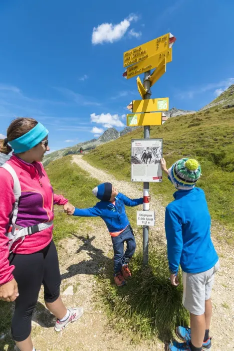 Framed Print : Mother and sons look at the signpost of hiking trails, Spluga Pass, Chiavenna Valley Framed Print : Mother and sons look at the signpost of hiking trails, Spluga Pass, Chiavenna Valley