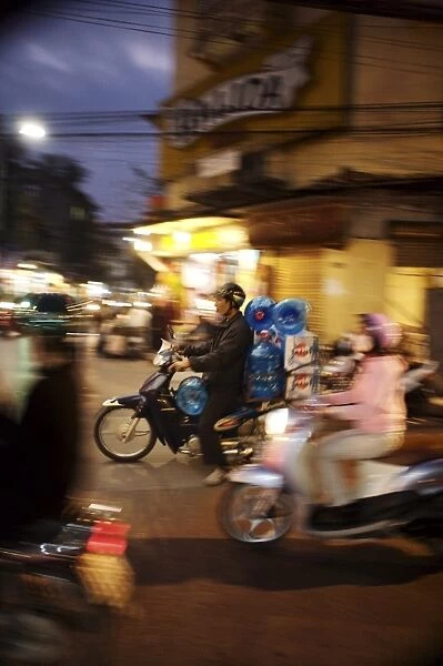 Motor cyclist carrying water bottles in traffic, Vietnam, Indochina, Southeast Asia, Asia
