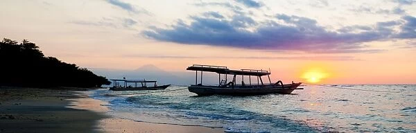 Mount Agung on Bali and fishing boats silhouetted against a sunset, Gili Trawangan, Gili Isles, Indonesia, Southeast Asia, Asia