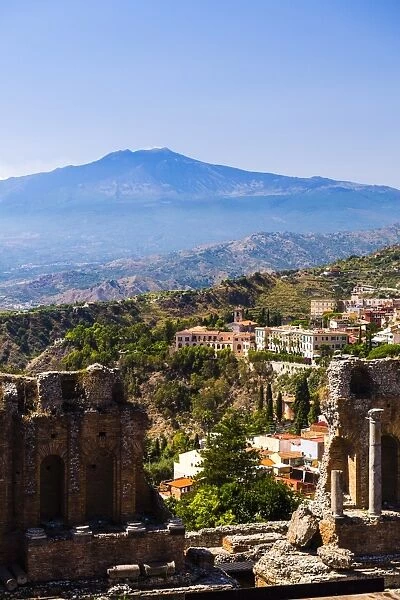 Mount Etna Volcano with ruins of Teatro Greco (Ancient Theatre) of Taormina in the foreground, Sicily, Italy, Europe