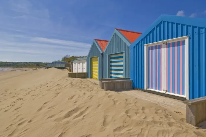 Framed Print : Multicoloured beach huts in the dunes on the long sweeping Morfa Gors beach
