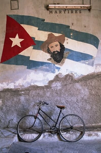 Mural of Camilo Cienfuergos on wall above a bicycle, Havana, Cuba, West Indies