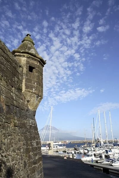 Muralhas de Sao Sebastiao (walls of St. Sebastian), fortress constructed to defend the bay of Porto Paim, and the marina, Horta, island of Faial, with Pico mountain on the island of Pico in the distance, Azores, Portugal