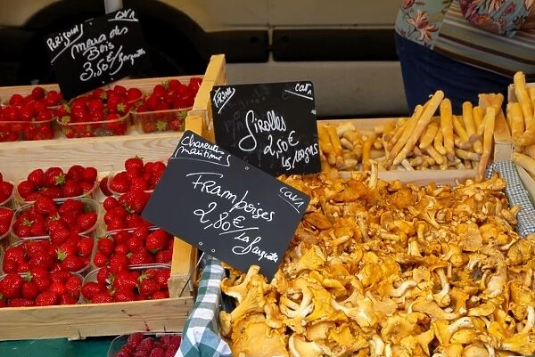 Mushrooms and strawberries on a market stall