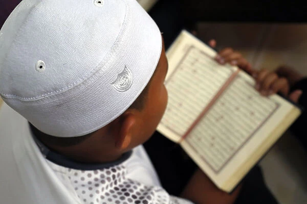 Muslim boy learning Quran at Islamic school, with Kufi hat, Ho Chi Minh City, Vietnam