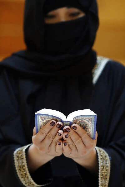 Muslim woman reading the Noble Quran, United Arab Emirates, Middle East