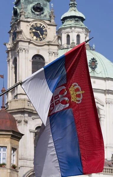 National flag in front of the dome of the Church of St. Nicholas, Prague