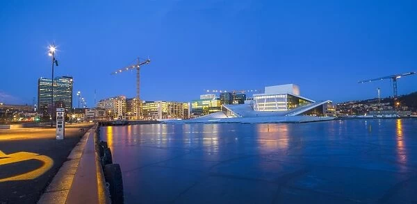 Night panoramic view of the Oslo Opera House, frozen bay and new business quarter