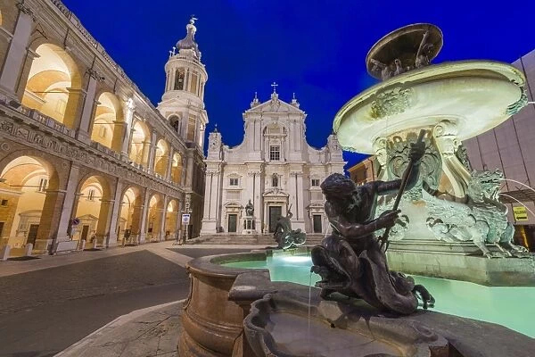 Night view of the Basilica of the Holy House and fountain decorated with statues