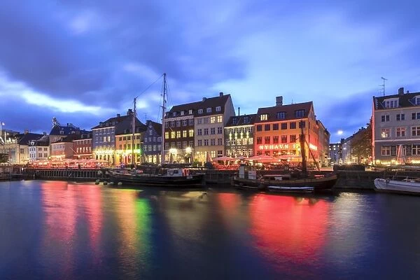 Night view of the illuminated harbour and canal of the entertainment district of Nyhavn