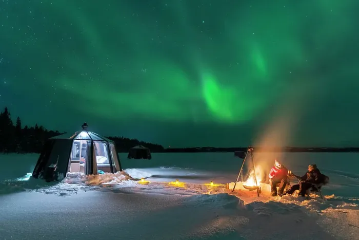 Framed Print : Night view of two people enjoyng dinner outside around a campfire close to the illuminated glass igloo with Northern Lights (Aurora Borealis) dancing in the sky, Jokkmokk, Norrbotten, Swedish Lapland, Sweden, Scandinavia, Europe