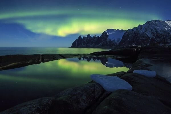 The Northern Lights (aurora borealis) and stars reflected in the icy sea, Tungeneset