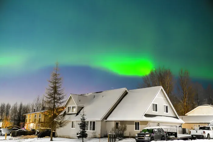 Framed Print : Northern lights (Aurora borealis) illuminate the night sky along the horizon behind mountains near Anchorage, Alaska, United States Of America