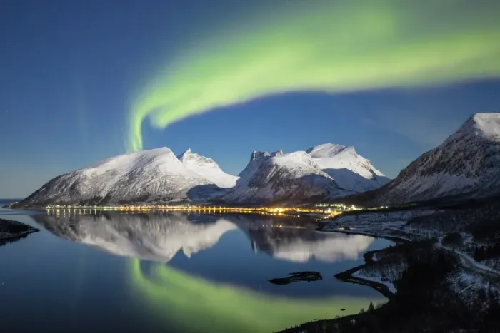 Framed Print : Northern lights (aurora borealis) and stars light up the snowy peaks reflected in the cold sea