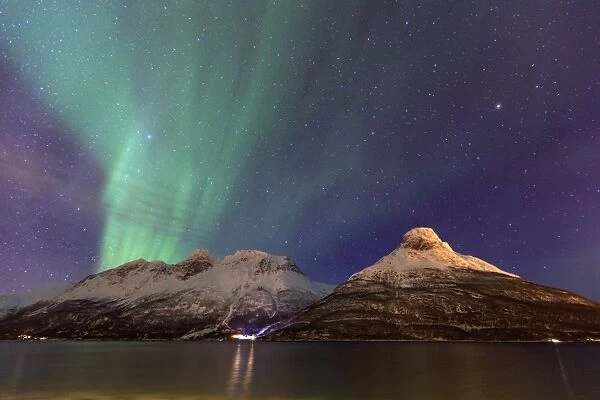 The Northern Lights illuminates the snowy peaks Oteren Storfjorden, Lyngen Alps, Troms