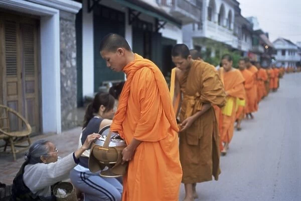 Novice Buddhist monks collecting alms of rice