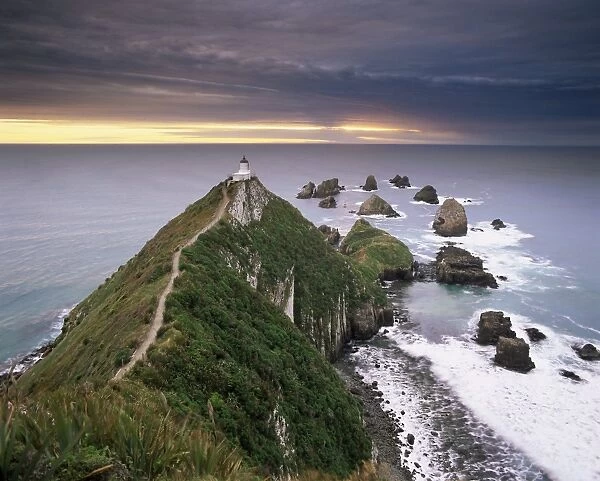 Nugget Point lighthouse on the coast and overcast sky