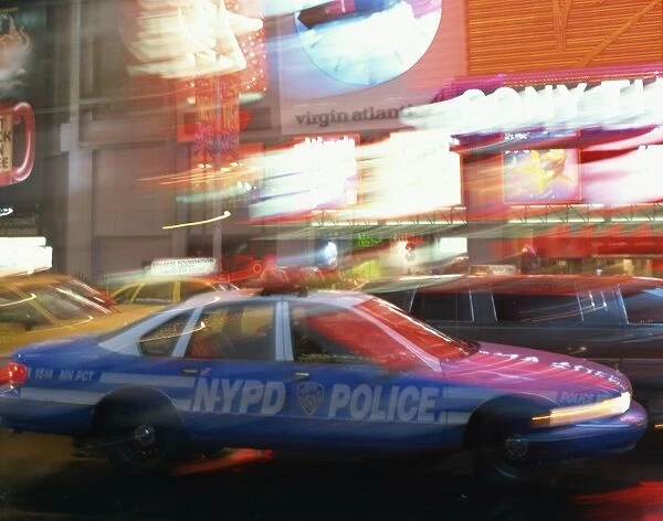NYPD police car speeding through Times Square, New York City, New York