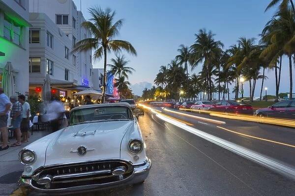Ocean Drive restaurants, vintage car and Art Deco architecture at dusk, South Beach
