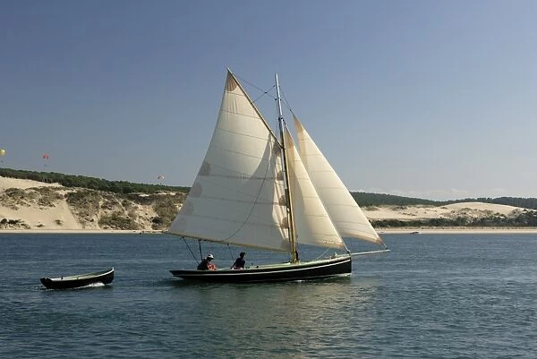Od gaff rigged sailing yacht and dinghy, sailing along Dune du Pyla, Bay of Arcachon
