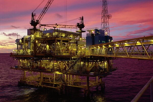 Oil rig illuminated at dusk