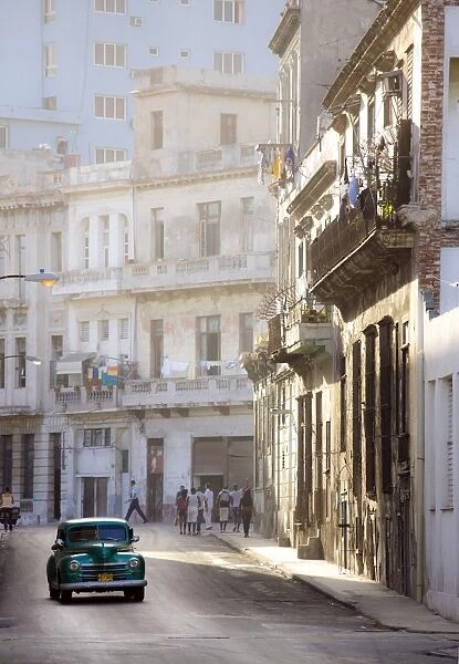 Old American car driving along quiet street in Havana Centro, Havana, Cuba