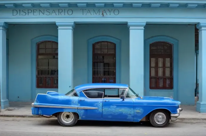 Framed Print : Old blue American car with body repairs parked in front of blue dispensary Framed Print : Old blue American car with body repairs parked in front of blue dispensary