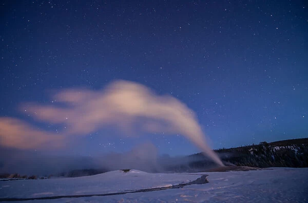 Old Faithful geyser under a starry sky, Yellowstone National Park