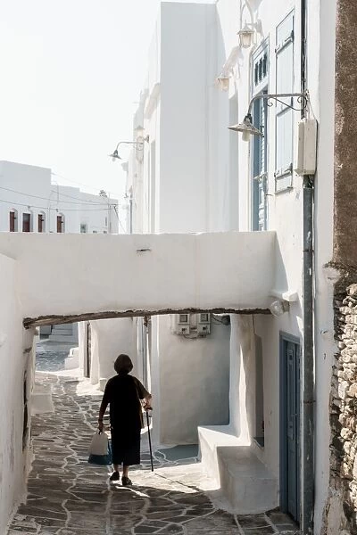 Old lady in black with stick and shopping walking home, Kastro Village, Sifnos, Cyclades