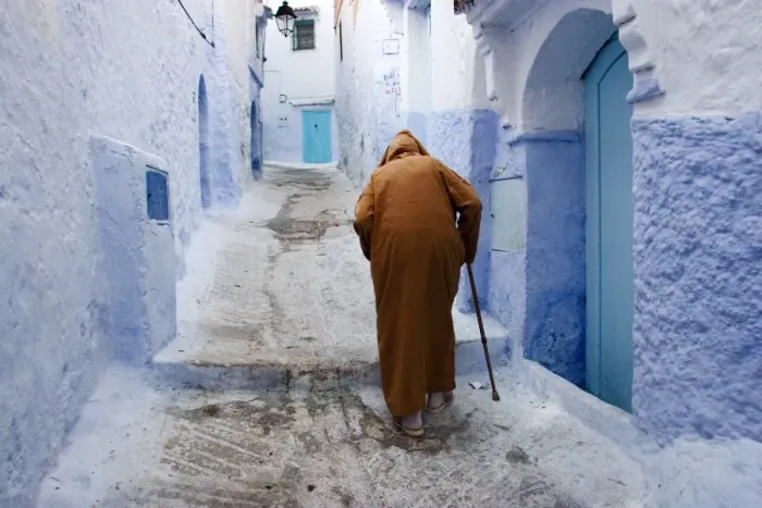 Framed Print : Old man walking in a typical street in Chefchaouen, Rif mountains region Framed Print : Old man walking in a typical street in Chefchaouen, Rif mountains region