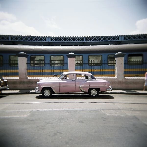 Old pink American car outside railway station, Havana, Cuba, West Indies, Central America
