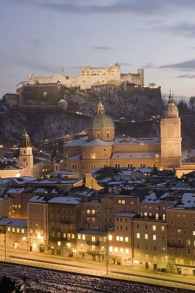 Old Town with towers of Glockenspiel, Dom and Franziskanerkirche churches dominated by the fortress of Festung Hohensalzburg at twilight, Salzburg