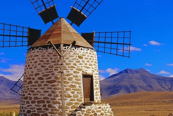 Old Windmill with volcanoes in background near Tefia