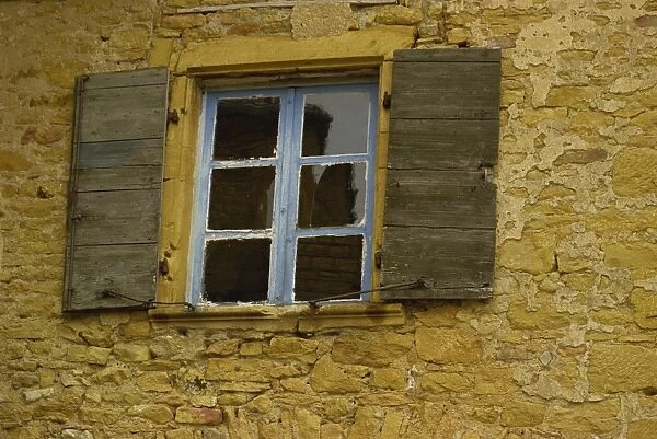 Detail of an old window with shutters on a stone house in the Rhone Alpes in France