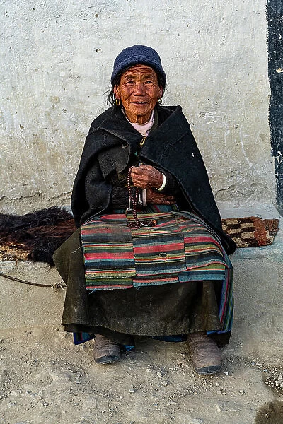 Old woman with a prayer wheel in her hand, Lo Manthang, Kingdom of Mustang, Nepal, Asia