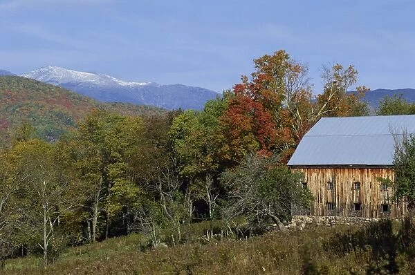 An old wooden farm building and trees in fall colours