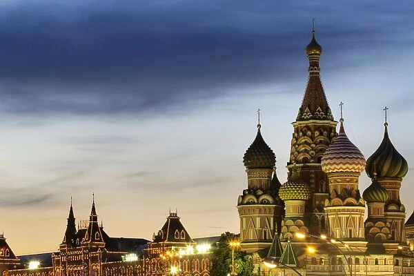The onion domes of St. Basils Cathedral and Gum department store in Red Square illuminated at night, UNESCO World Heritage Site, Moscow, Russia, Europe