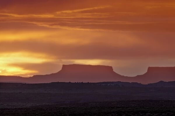 Orange clouds behind a butte at sunset, Canyon Country, Utah, United States of America