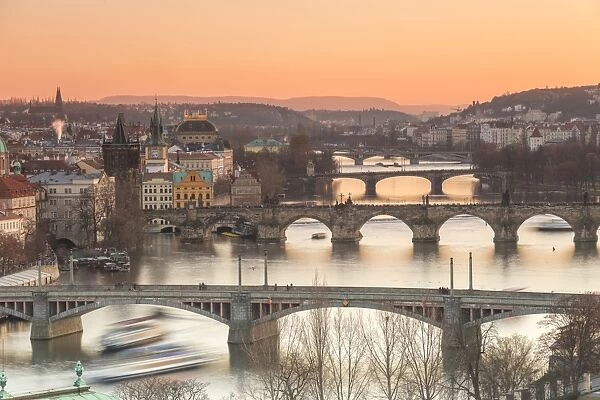 Orange sky at sunset on the historical bridges and buildings reflected on Vltava River