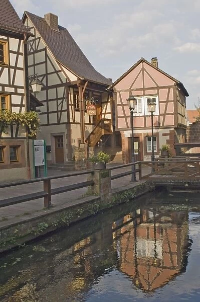 Original timber framed houses reflected in the mill race
