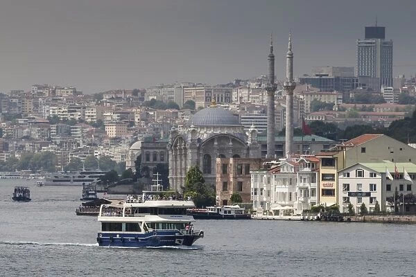 Ortakoy Mecidiye Mosque and passenger ferry, Ortakoy, from Bosphorus Strait with Istanbul city skyline behind, Istanbul, Turkey, Europe
