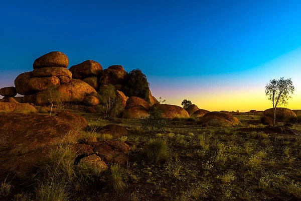 Outback landscape of Devils Marbles rock formations after twilight, granite boulders