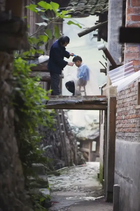 Framed Print : An outdoor barber cutting a boys hair in Langde village, Guizhou Province Framed Print : An outdoor barber cutting a boys hair in Langde village, Guizhou Province