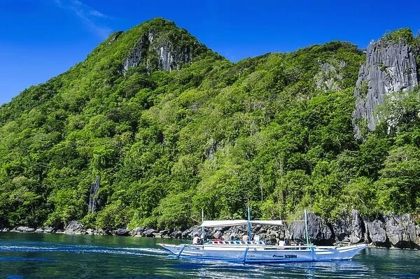 Outrigger boat cruising in the bay of El Nido, Bacuit Archipelago, Palawan, Philippines, Southeast Asia, Asia