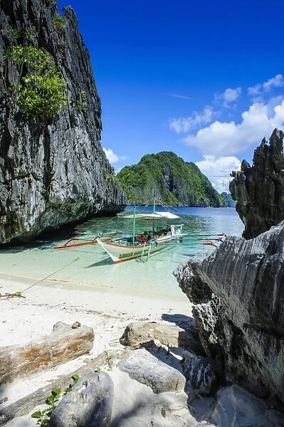 Outrigger boat on a little white beach and crystal clear water in the Bacuit archipelago, Palawan, Philippines, Southeast Asia, Asia