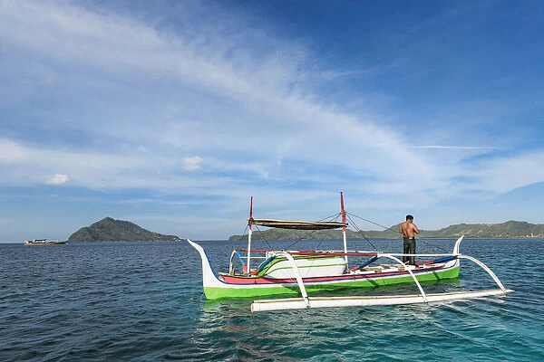 Outrigger canoe off Bahuis Island and the southern tip of Siau, Siau Island, Sangihe Archipelago, North Sulawesi, Indonesia, Southeast Asia, Asia