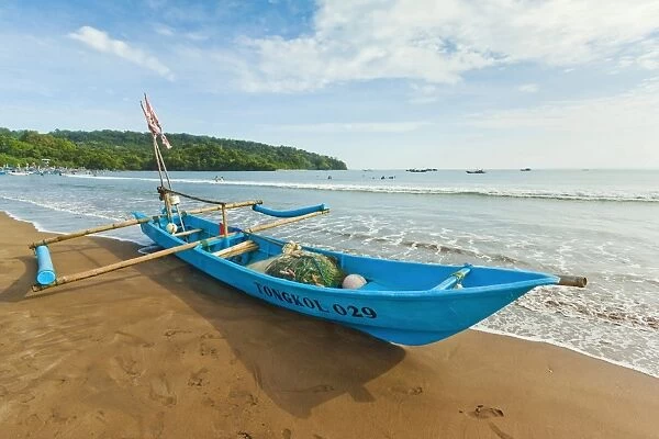 Outrigger fishing boat on west beach of the isthmus at this major beach resort on the south coast, Pangandaran, Java, Indonesia, Southeast Asia, Asia