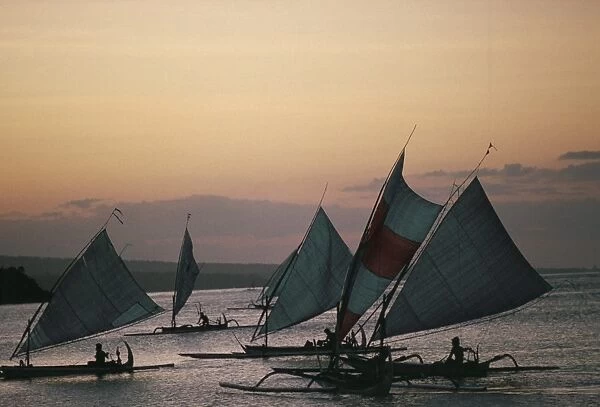 Outrigger fishing boats under sail