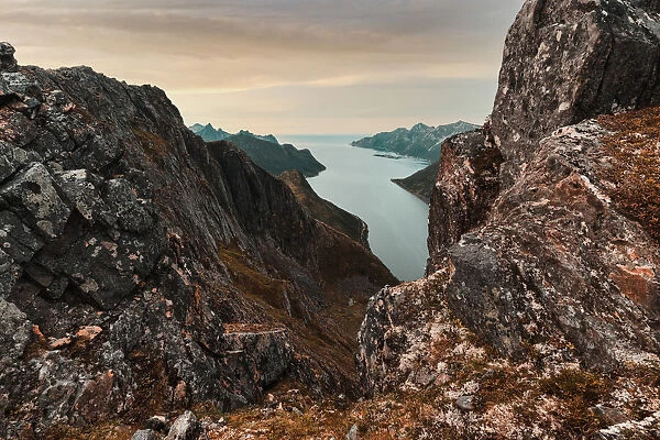 Oyfjorden fjord view from steep hiking trail through red rocks of mountains, Senja island